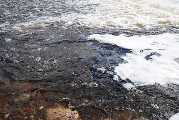 Bubbles formed on water surface from turbulence in river