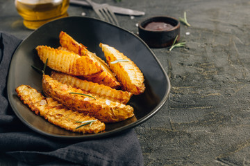 Homemade organic French fries with pink salt and cranberry sauce on black background.