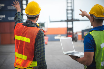 Foreman engineer working in container yard, Quality control Inspector using laptop for checking on container site, logistic store for import and export concept