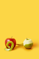 Whole red apple and half-skinned green apple