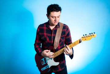 Obraz premium Young handsome man posing and playing guitar