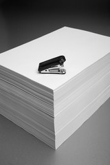 Stapler on top of a stack of paper