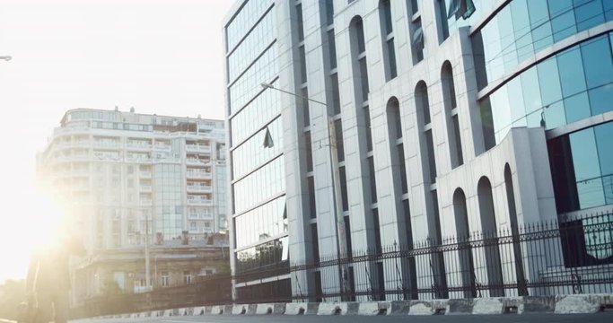 A man in a suit rides on a gyroboard and talks on the phone against the background of a business center.