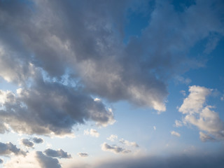 Naklejka na ściany i meble Beautiful bizarre clouds fly through the evening blue sky. Summer day