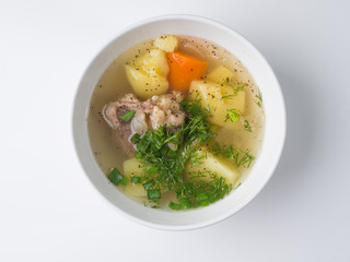 Shurpa soup. Beef with potatoes and carrots in a broth in a white bowl. Top view