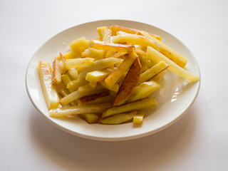Appetizing fried potatoes on a white plate. Side view