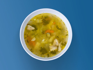 Chicken soup in a bowl on a wooden surface. Hot dish