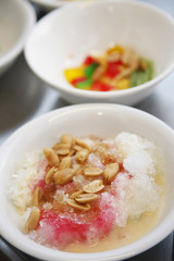 Shaved ice with coloured syrup and condensed milk topped with peanuts