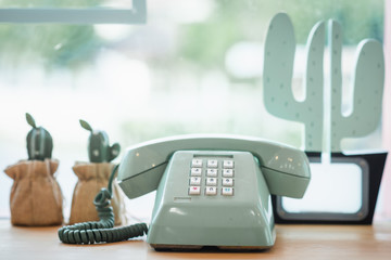 Retro green rotary telephone on wood table