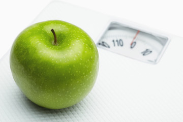 Green apple on a weighing scale