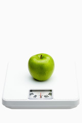 Green apple on a weighing scale