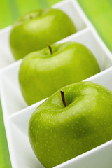 Green apples placed in a ceramic dish
