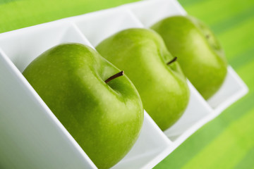 Green apples placed in a ceramic dish