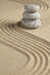 Fototapeta na wymiar Three stones stacked on raked sand