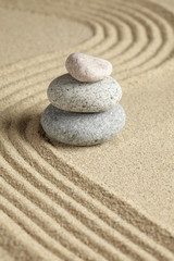 Fototapeta na wymiar Three stones stacked on raked sand