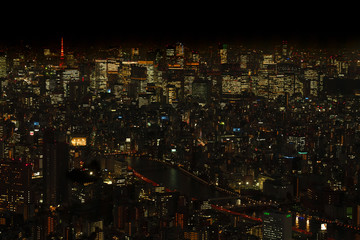 Tokyo night view from Tokyo Sky Tree, buildings have lights on and Tokyo Tower is lit up in red.