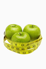 Measuring tape wound around three apples