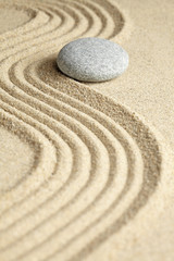 Fototapeta na wymiar Stone on rippled and smooth sand