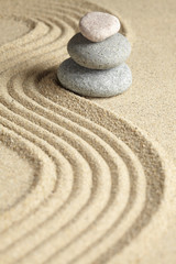 Three stones stacked on raked sand