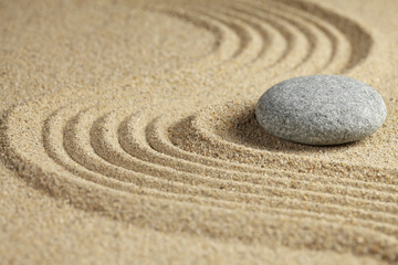 Fototapeta na wymiar Single stone on sand