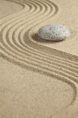 Fototapeta na wymiar A stone placed beside a rippled surface sand