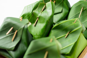 Obraz premium Thai dessert (Khao Niao Sangkhaya), Sweet sticky rice with egg custard wrapping with fresh banana leaf 