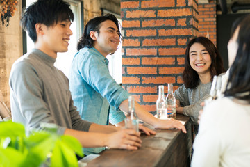 バーカウンターで談笑する男女グループ