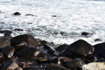 Fototapeta premium Waves break on stony rocky beach seashore