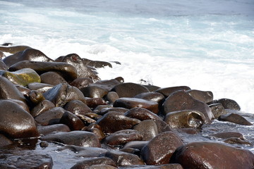 Waves break on stony rocky beach seashore