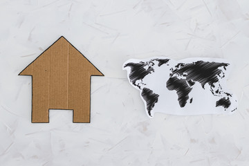 staying home during the global lockdown, world map and house icon side by side