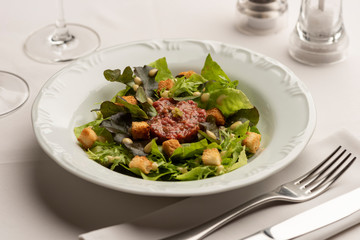 Green salad with lettuce tomatoes on white blurred background