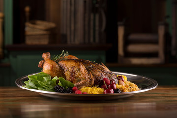 Roasted turkey chicken garnished with blackberry, red berry, cherries, and spices