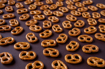 Pretzel cookies are spread out on a brown background