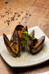 mussel on white plate fork and knife.