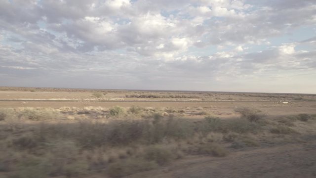 Panning shot of landscape from train window against cloudy sky, beautiful rail journey at remote location - Swakopmund, Namibia