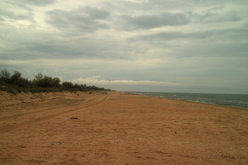 Deserted sandy beach. Overcast sky. loneliness. Rain clouds.
