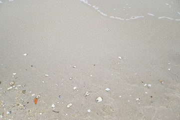 Soft wave with blue ocean on sandy beach.