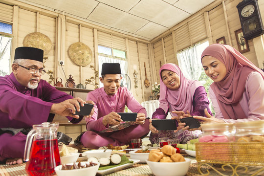 Muslim family taking pictures of food during the Eid al-Fitr