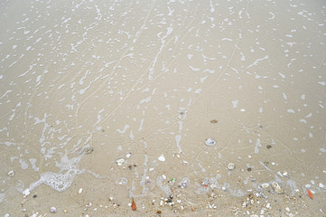 Soft wave with blue ocean on sandy beach.