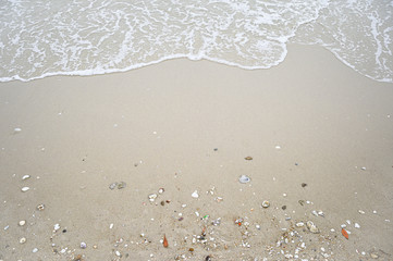 Soft wave with blue ocean on sandy beach.