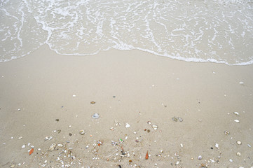 Soft wave with blue ocean on sandy beach.