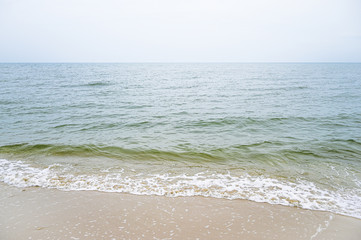 Soft wave with blue ocean on sandy beach.
