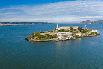 Fototapeta na wymiar Aerial view of Alcatraz Island in San Francisco Bay, California, USA. Morning light, Golden Gate Bridge in the background.