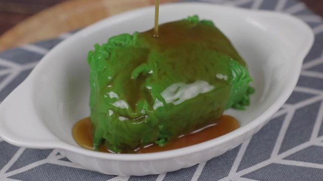 Pouring coconut syrup on rice noodles made of rice eaten with coconut cream ,Lod Chong, Singapore rice noodle, made with pandan syrup in coconut milk and melon, traditional Thai desserts in Thailand