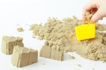 Castles in the sand close up isolated on white background.