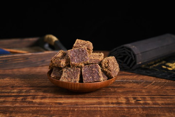 Brown sugar lumps were placed on a plate on a vintage wooden table