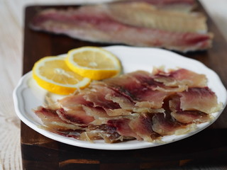 Fish background.Pieces of freshly salted Russian river fish, home-salted, ready to eat, on the kitchen cutting Board on a white wooden table.