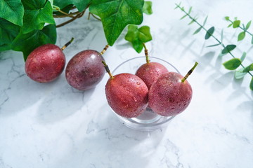 The washed passion fruit sits on a plate, bathed in the sun