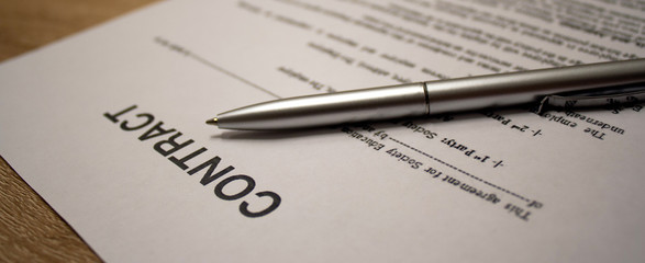 Macro shot of legal contract and pen lying on the table. Documents for business. Web banner of contract and pen for the site. 