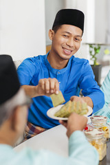 Muslim man holding traditional Malay layer cake